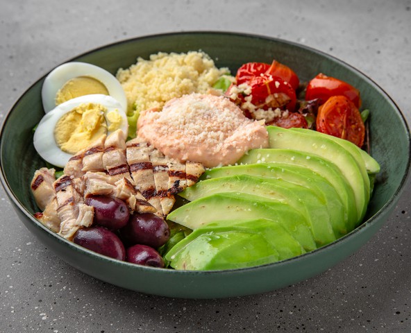 Bowl salad with grilled chicken fillet, couscous, avocado and chipotle sauce