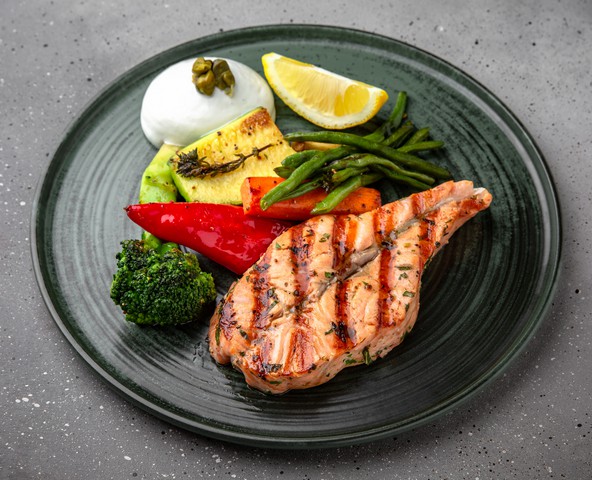 Salmon steak with vegetables and hollandaise sauce